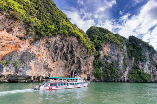 A boat cruise offers breathtaking views of lush cliffs under a bright blue sky.
